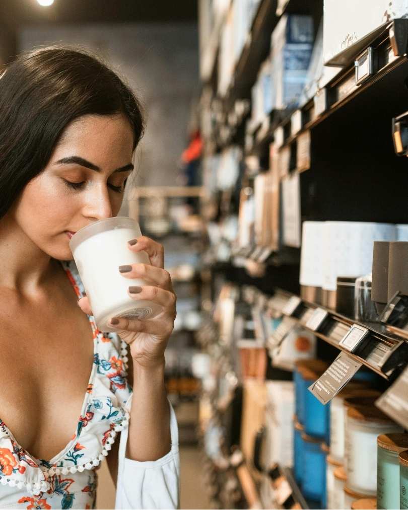 Ragazza che annusa la candela in negozio