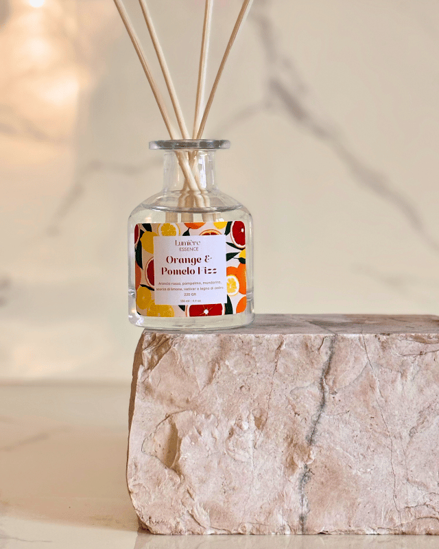 Diffusore a bastoncino in bottiglietta di vetro su pietra di marmo 