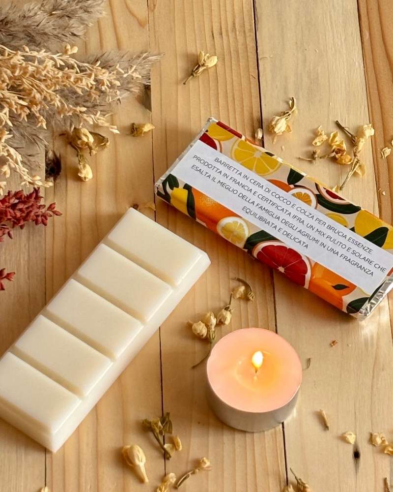 Foto barrette Orange Pomelo in cera di cocco  vista del retro dell'etichetta con piccola candela e fiori decorativi affianco