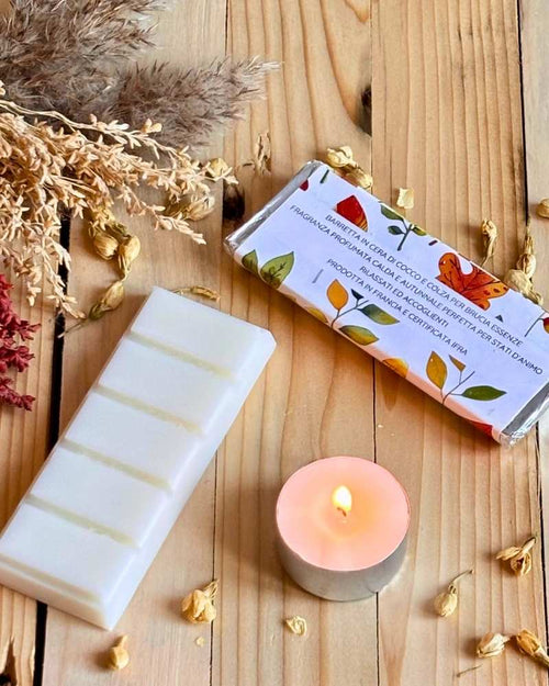 foto barretta snaggle season con etichetta dal retro on piccola candela affianco e barretta in cera di cocco affianco ben visibile 