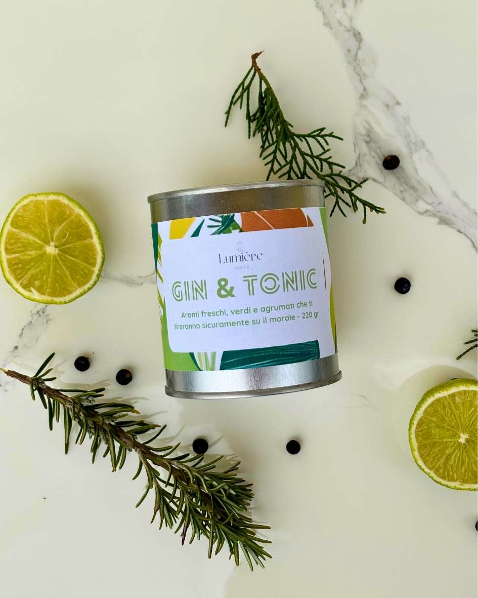 Candela Gin&Tonic Lumière Essence -  barattolo con attorno rosmarino ginepro e lime su un piano di marmo