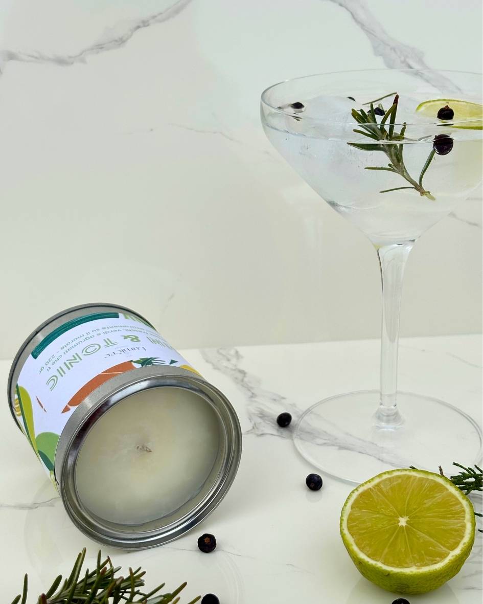 Candela Gin&Tonic Lumière Essence -  barattolo con attorno rosmarino ginepro e lime su un piano di marmo