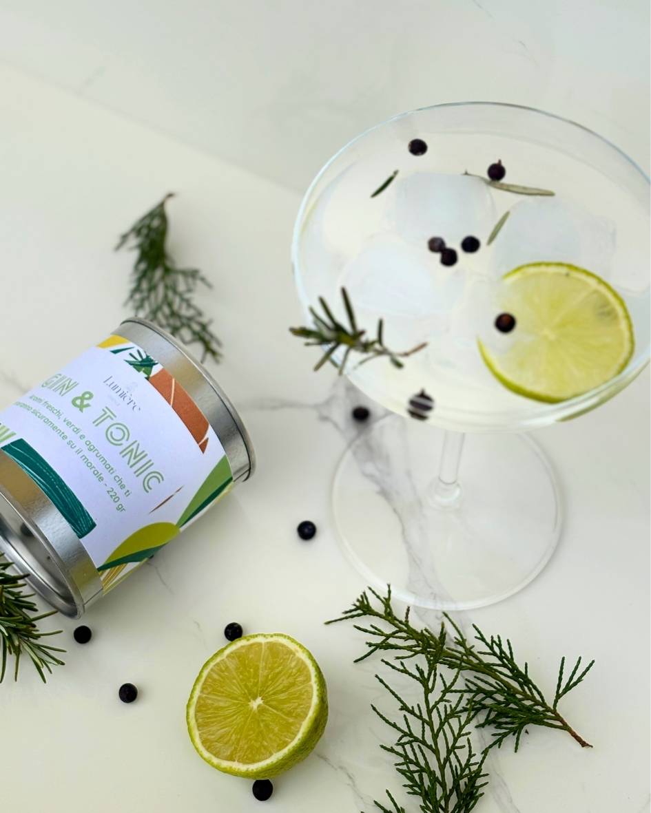 Candela Gin&Tonic Lumière Essence -  barattolo con attorno rosmarino ginepro e lime su un piano di marmo