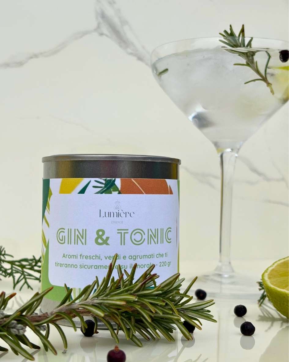 Candela Gin&Tonic Lumière Essence -  barattolo con attorno rosmarino ginepro e lime su un piano di marmo