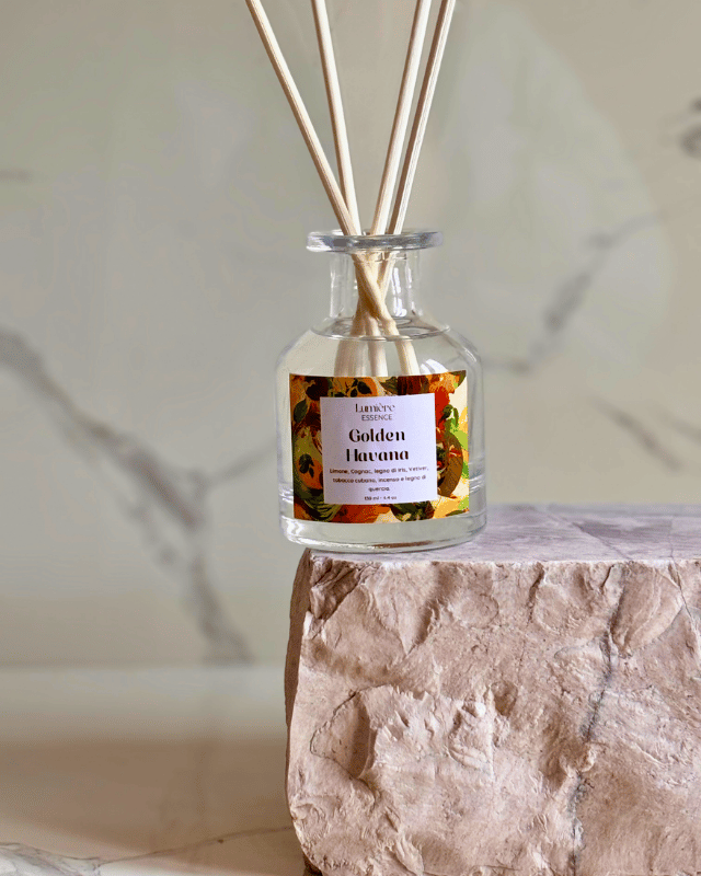 Diffusore a bastoncino in bottiglietta di vetro su pietra di marmo