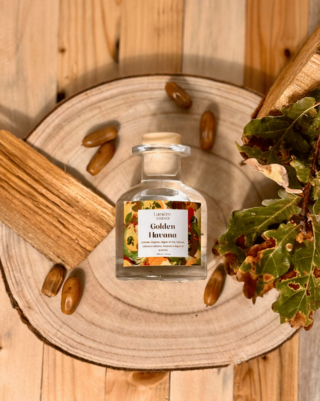 Diffusore a bastoncino in bottiglietta di vetro in sfondo autunnale e foglie, semi e legno di quercia