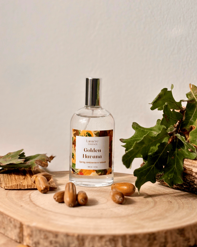 Spray in bottiglietta di vetro profuma ambiente e tessuti sullo sfondo foglie semi e legno di quercia