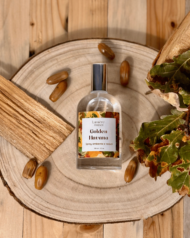 Spray in bottiglietta di vetro profuma ambiente e tessuti sullo sfondo foglie semi e legno di quercia riresa dall'alto