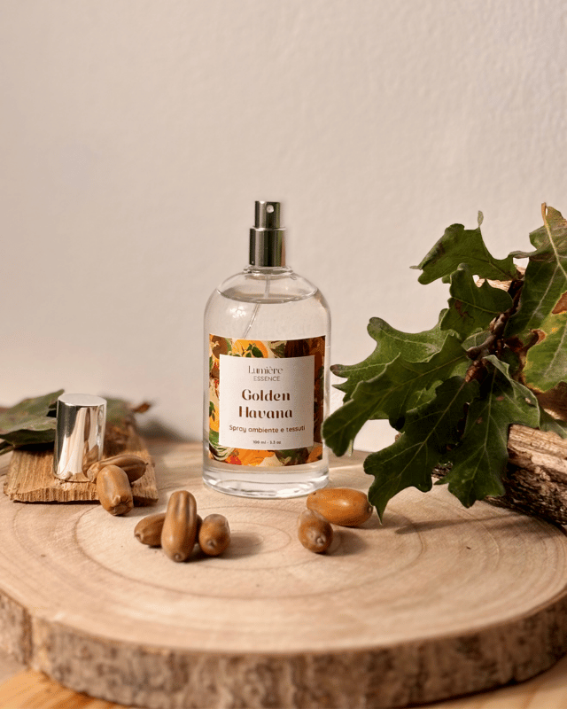 Spray in bottiglietta di vetro profuma ambiente e tessuti sullo sfondo foglie semi e legno di quercia