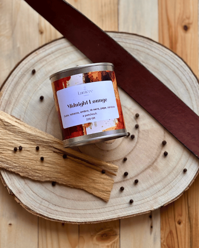 candela su anello di legno legno di sandalo, chicchi di pepe e cintura in cui che richiamano i profumi intensi della fragranza.