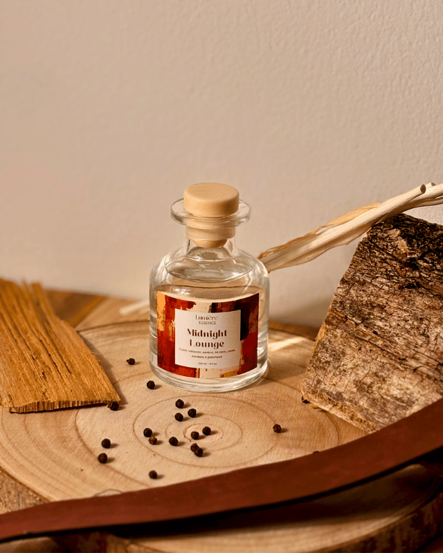 Diffusore a bastoncini in bottiglietta di vetro con ambientazione invernale con legno di sandalo e chicchi di pepe