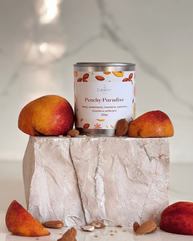 Candela in barattolo di latta realizzata in cera di cocco naturale con pesce mature che richiamano la fragranza su pietra di marmo