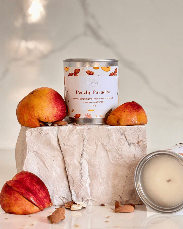 Candela in barattolo di latta realizzata in cera di cocco naturale con pesce mature che richiamano la fragranza su pietra di marmo e una candela che mostra l'interno del barattolo