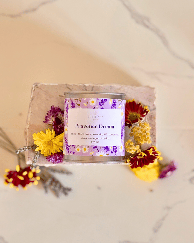 Candela in barattolo di latta realizzata in cera di cocco con fiori di lavanda e crisantemi su pietra di marmo vista dall'alto