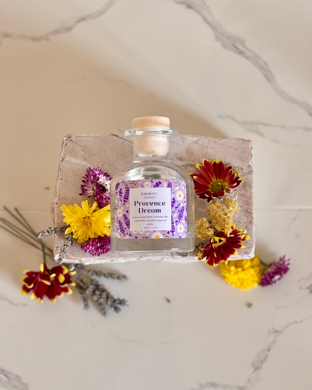 Diffusore per ambiente a bastoncino in bottiglietta di vetro su pietra di marmo fiori di lavanda fiori che rappresentano la fragranza vista dall'alto