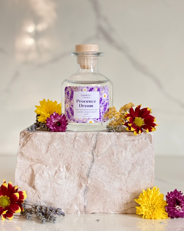 Diffusore per ambiente a bastoncino in bottiglietta di vetro su pietra di marmo fiori di lavanda fiori che rappresentano la fragranza