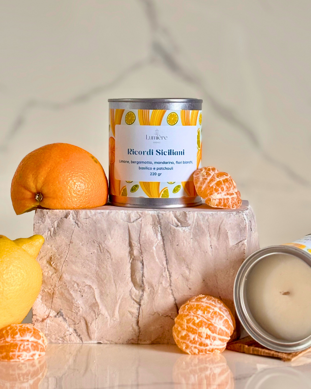 Candela in barattolo di latta realizzata in cera di cocco su pietra di marmo e agrumi che rappresentano la fragranza e candela che mostra l'interno della candela