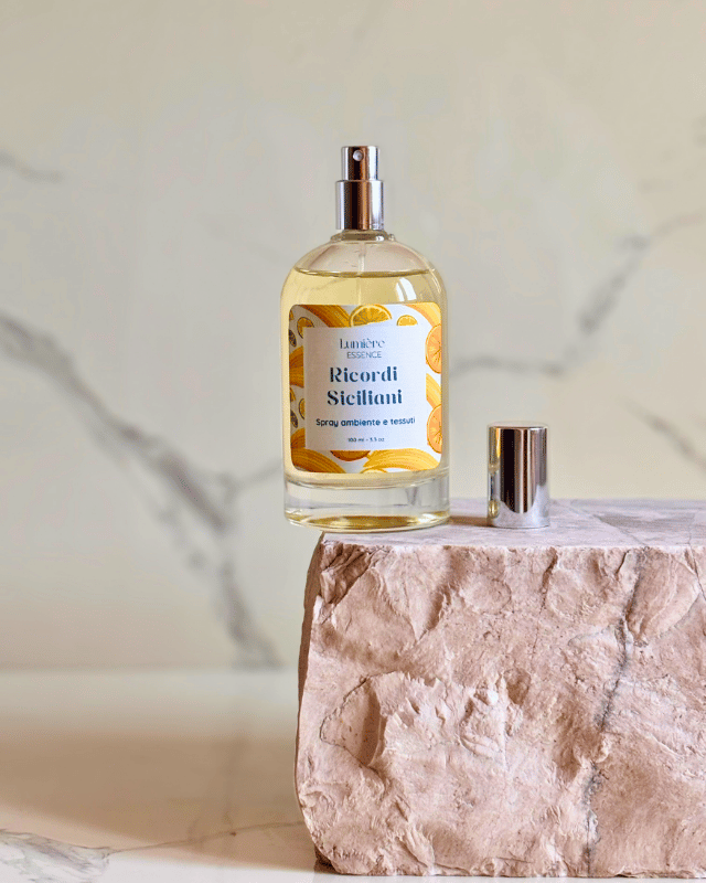 Spray per ambienti e tessuti in bottiglietta di vetro su pietra di marmo