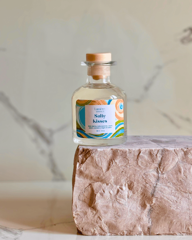 Diffusore a bastoncino in bottiglietta di vetro su pietra di marmo