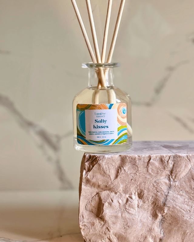 Diffusore a bastoncino in bottiglietta di vetro su pietra di marmo