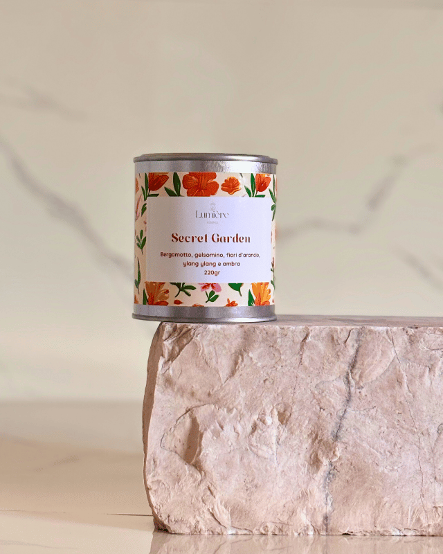 candela in cera di cocco in barattolo di latta dal profumo floreale su pietra di marmo