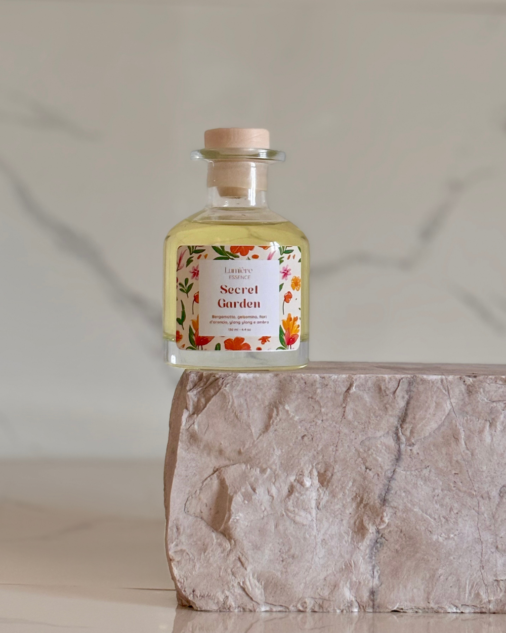 Diffusore a bastoncino in bottiglietta di vetro su pietra di marmo