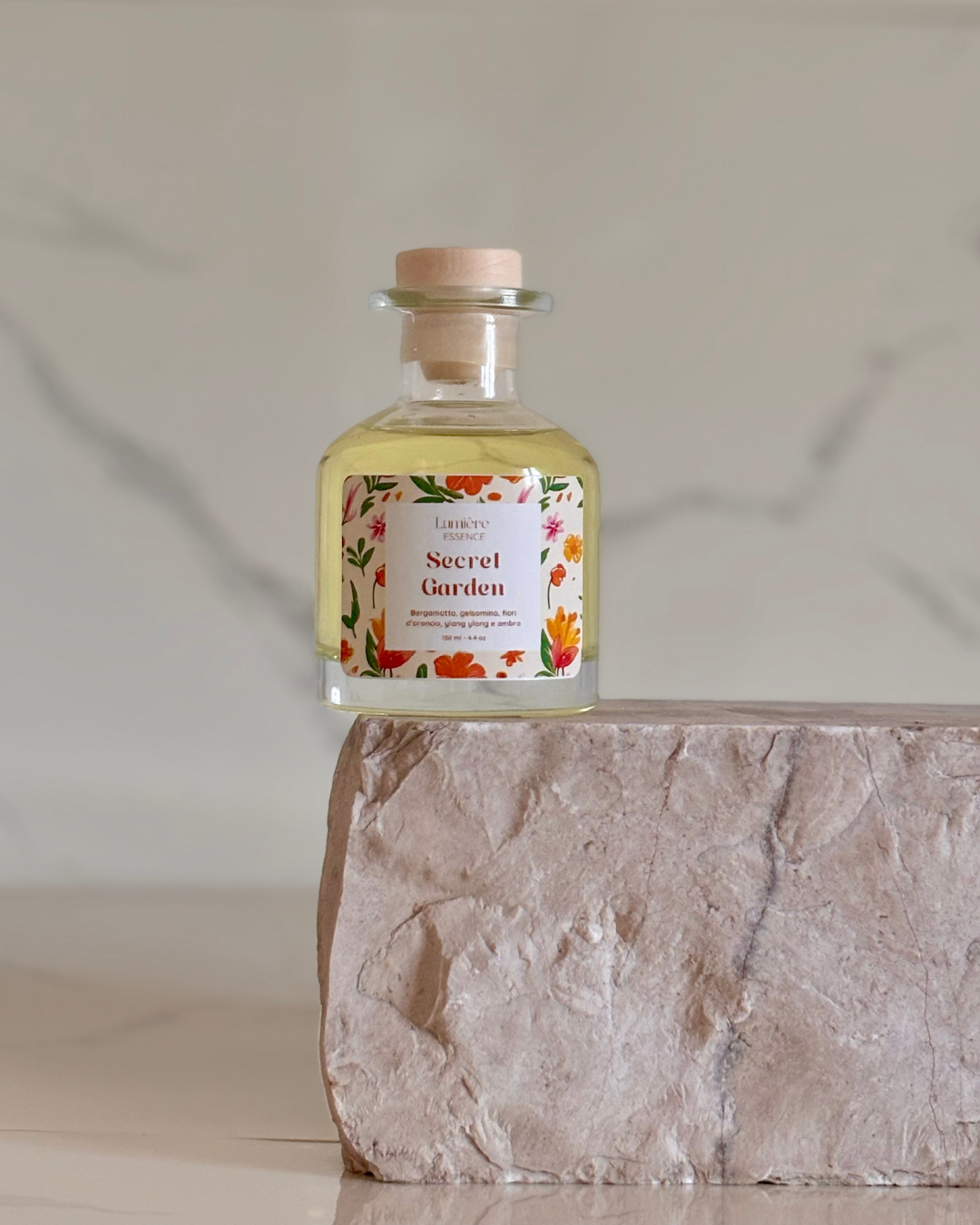 Diffusore a bastoncino in bottiglietta di vetro su pietra di marmo