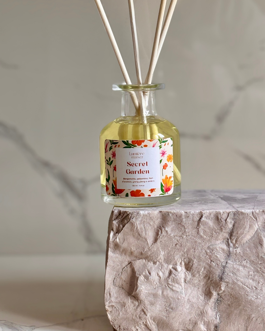 Diffusore a bastoncino in bottiglietta di vetro su pietra di marmo