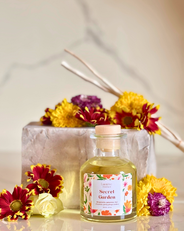 Diffusore per ambiente a bastoncino sullo sfondo pietra di marmo con fiori