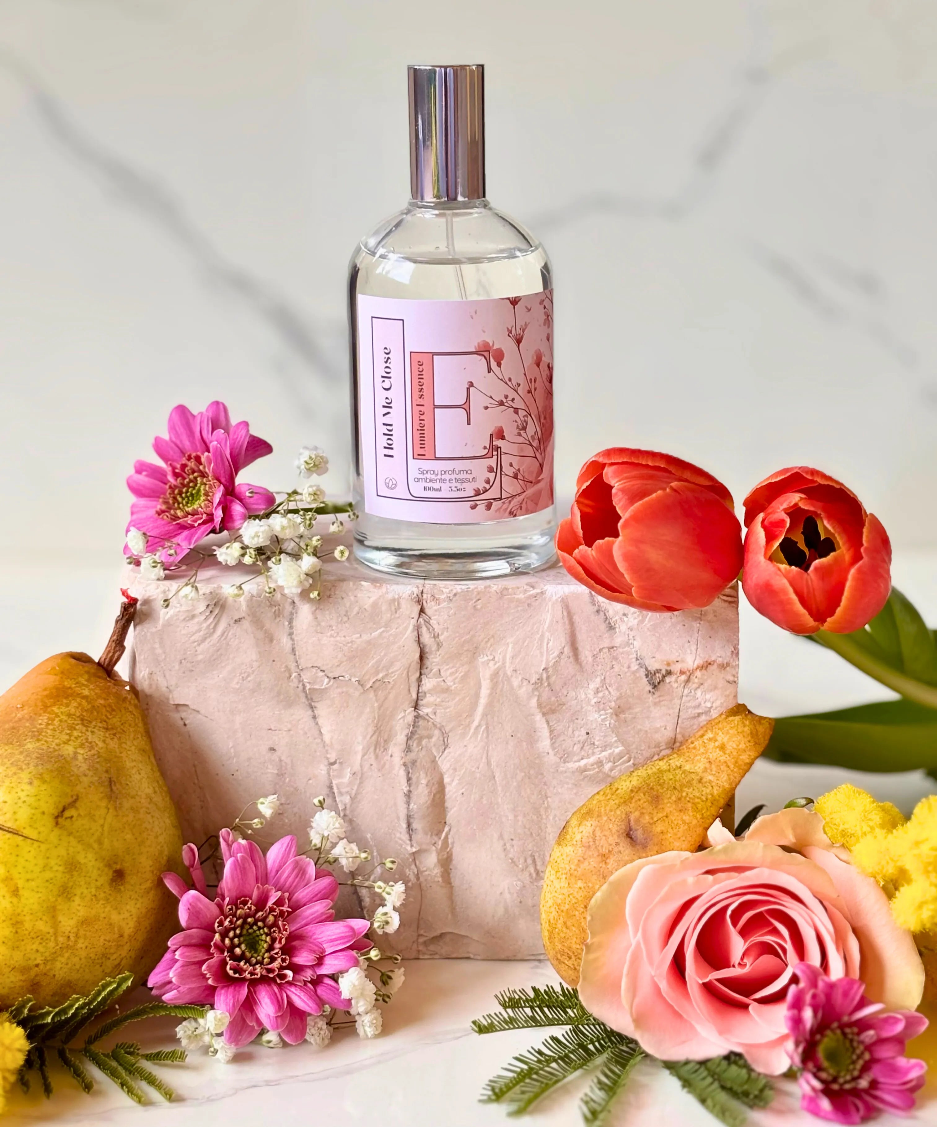 Spray per ambiente e tessuti Hold Me Close, flacone elegante da 100ml su sfondo luminoso.