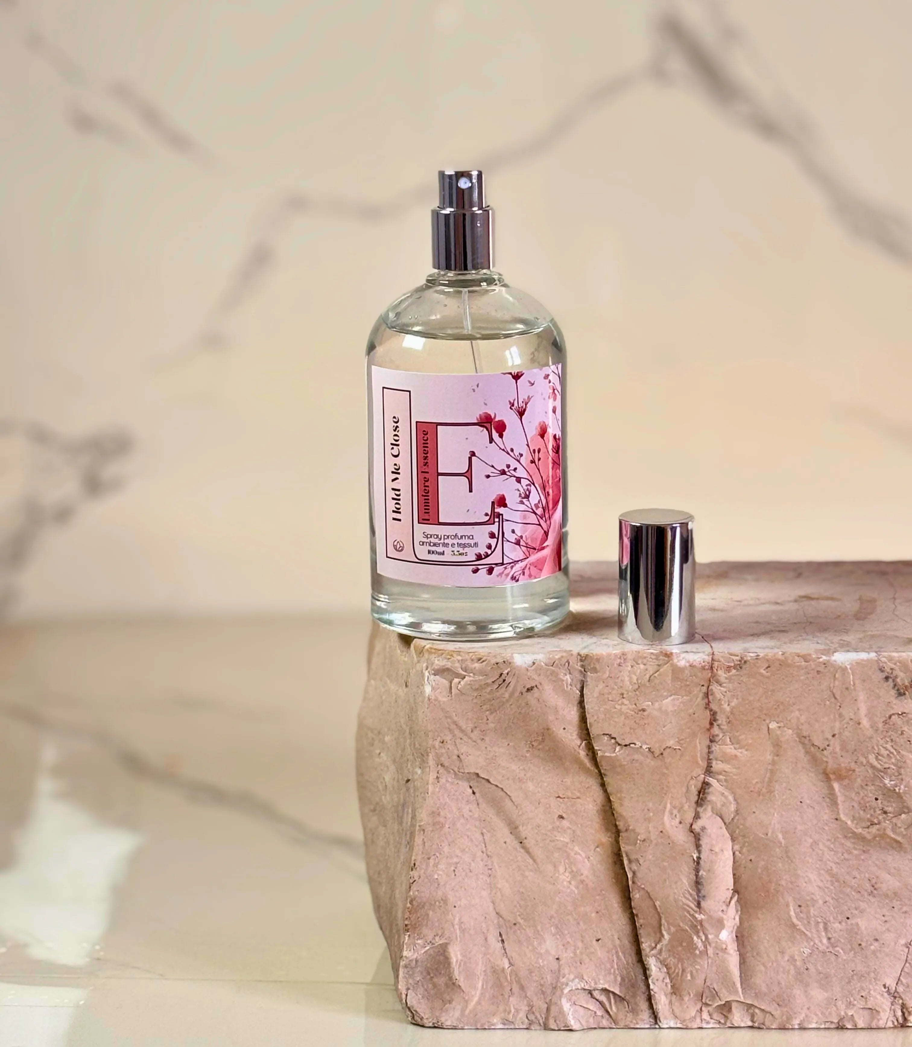 Spray profuma ambiente e tessuti Hold Me Close in flacone elegante da 100ml su uno sfondo neutro.