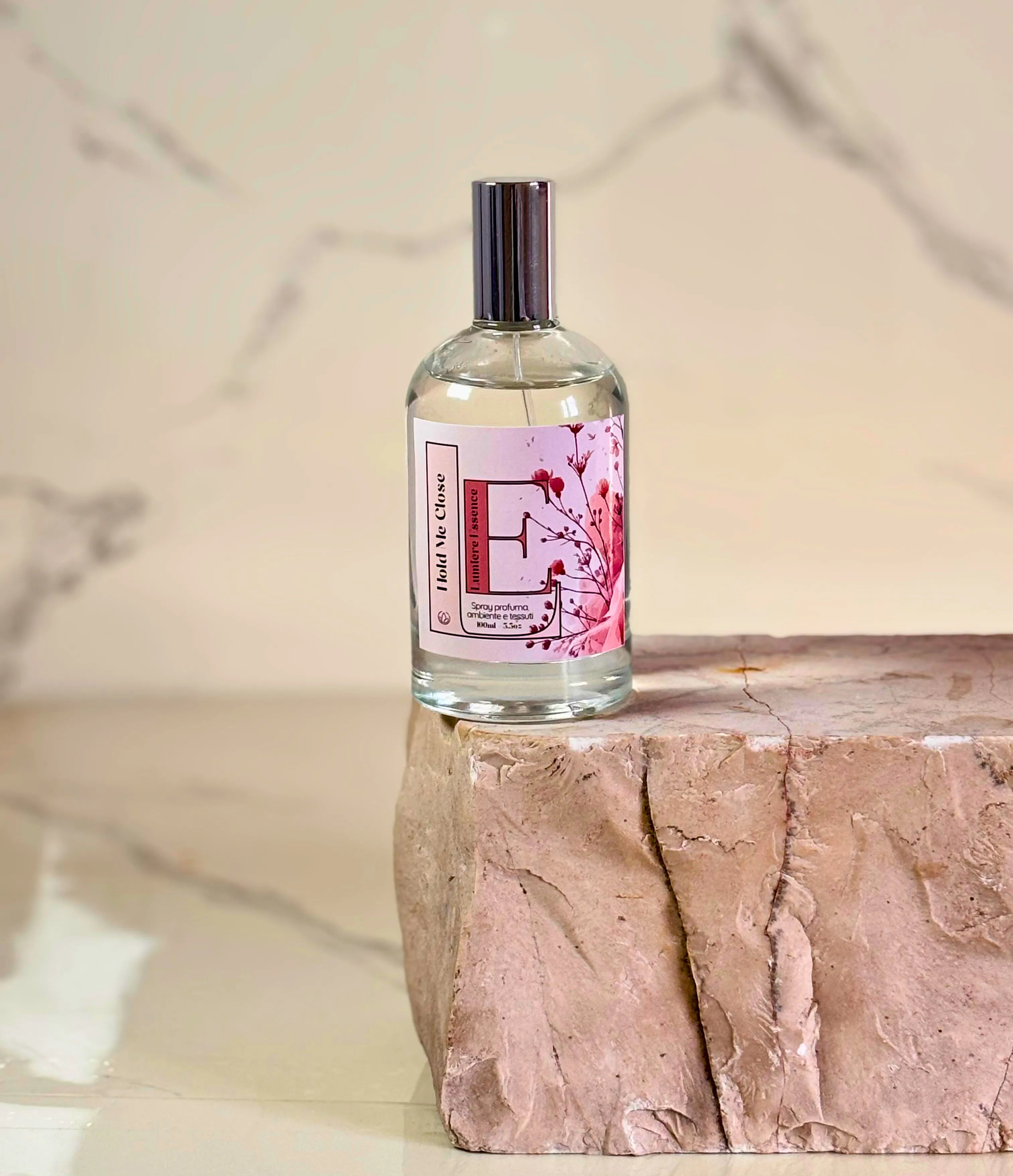 Spray profumante per ambiente e tessuti Hold Me Close, confezione da 100 ml in un'elegante bottiglia.