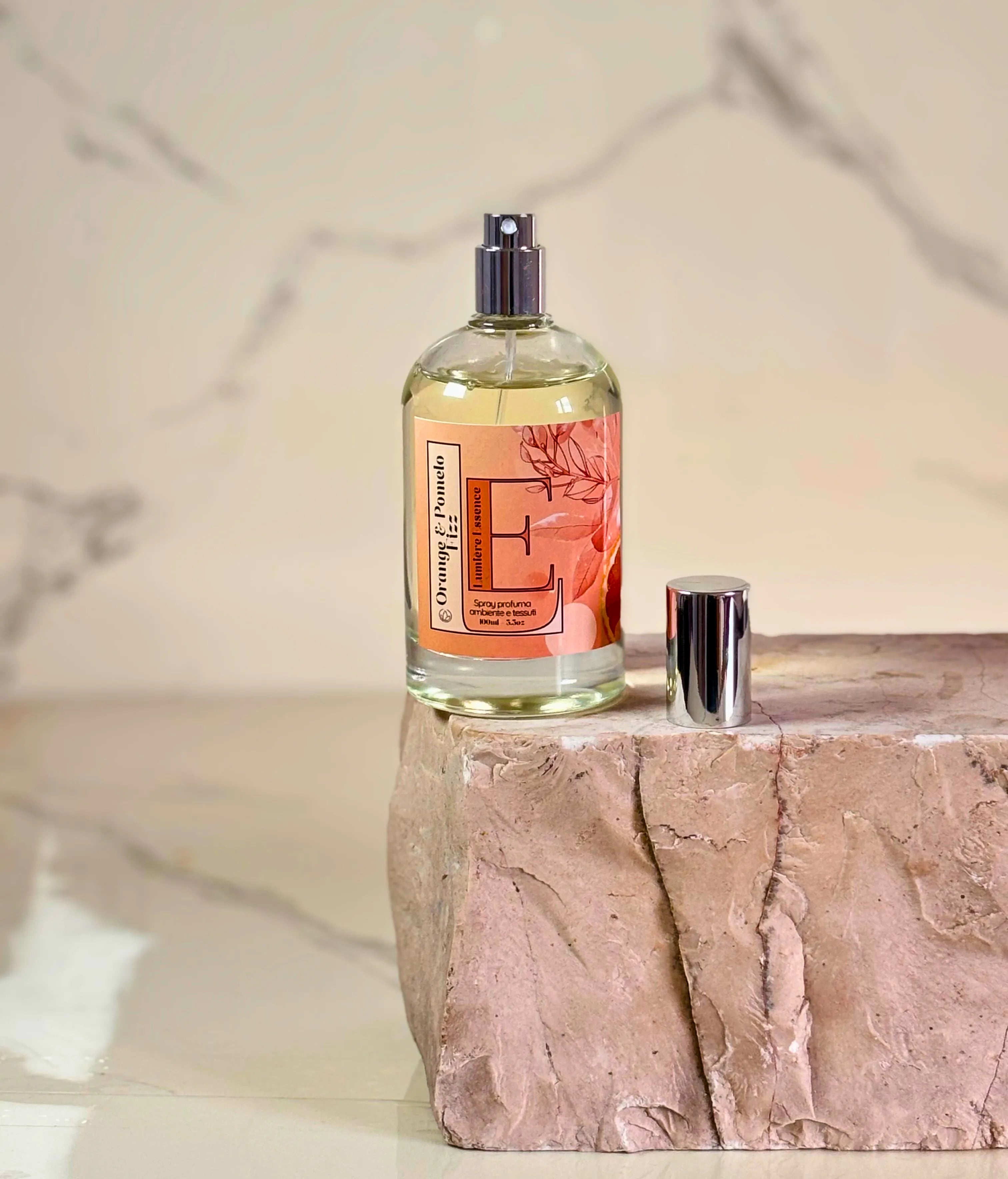 Spray profumatore per ambiente e tessuti Orange&Pomelo Fizz in bottiglia da 100ml su sfondo chiaro.