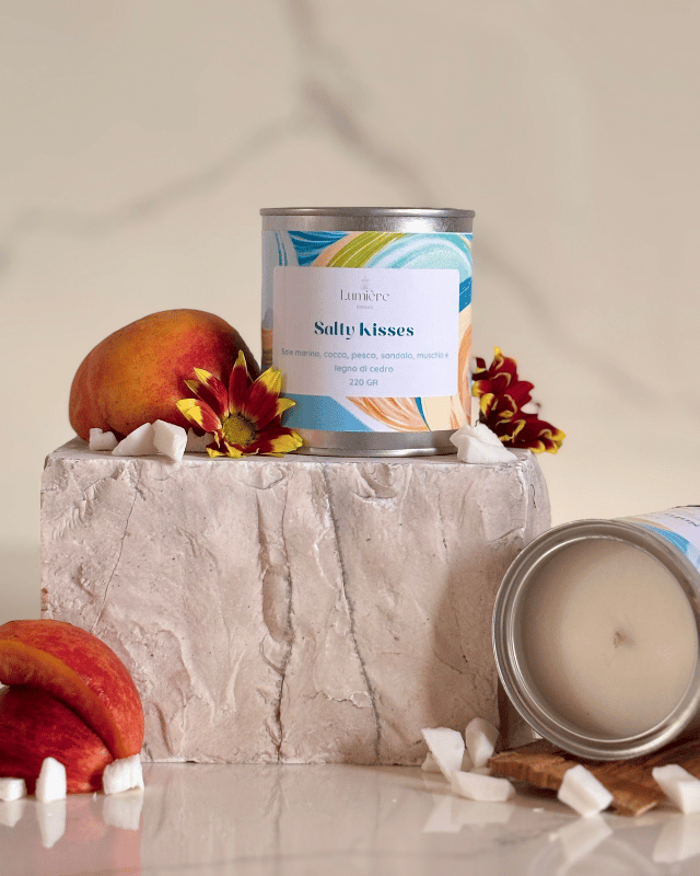 candela in barattolo di latta con decorazioni floreali e una candela che mostra il suo interno in cera di cocco