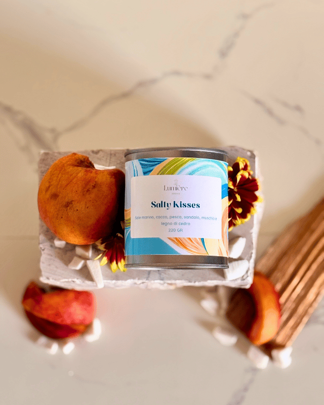 candela in barattolo di latta con decorazioni floreali  su pietra di marmo vista dall'alto